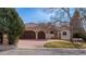 Attractive home featuring a red tile roof, three-car garage, stucco siding, and mature landscaping at 7022 Secrest Ct, Arvada, CO 80007