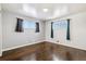 Bright and airy bedroom featuring hardwood floors and natural light from two windows at 348 Emery Rd, Northglenn, CO 80233