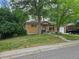 Charming brick home with well-maintained lawn, mature trees, and inviting front entrance at 348 Emery Rd, Northglenn, CO 80233