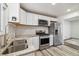 Well-lit kitchen boasts stainless steel appliances, granite countertops, and white cabinets at 348 Emery Rd, Northglenn, CO 80233