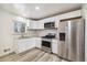 Modern kitchen featuring white cabinets, stainless steel appliances, and a bright window at 348 Emery Rd, Northglenn, CO 80233