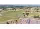 Expansive aerial view of land with scattered trees, a winding path, and distant town views at 8855 E Parker Rd, Parker, CO 80138