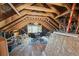 This attic is large with exposed beams, a ceiling fan, and a window at 8855 E Parker Rd, Parker, CO 80138