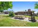 Landscaped backyard patio with a dining table, chairs, bench seating, and the back of the brick home at 8855 E Parker Rd, Parker, CO 80138