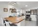 Well-lit kitchen featuring white cabinetry, stainless steel appliances, and a breakfast bar with seating at 6896 Ruth Way, Denver, CO 80221