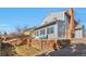 Back exterior featuring blue siding, a brick chimney, a patio and tiered landscaping enhancing the home's curb appeal at 2079 S Quintero St, Aurora, CO 80013