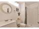 This bathroom features white ceramic tile shower and commode with a round mirror and vanity at 2079 S Quintero St, Aurora, CO 80013