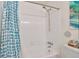 This shower features a white ceramic tile enclosure, and blue themed shower curtain at 2079 S Quintero St, Aurora, CO 80013