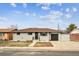Charming single-story home featuring a grey brick exterior, a driveway, and a well-maintained front lawn at 235 N 12Th Ave, Brighton, CO 80601