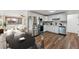 Modern kitchen featuring stainless steel appliances and sleek white cabinets and an adjacent living room with large windows at 235 N 12Th Ave, Brighton, CO 80601