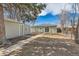 A backyard with an outbuilding, concrete walkway, partial fence, and sliding glass door access to the main house at 1248 Moline St, Aurora, CO 80010