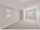 An empty bedroom with neutral walls has two windows, plush carpet, and a closet at 1248 Moline St, Aurora, CO 80010