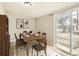 Dining room with a rustic wood table, modern chairs, and sliding doors to the backyard at 1248 Moline St, Aurora, CO 80010