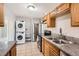 Efficient kitchen with stainless steel appliances, stacked washer/dryer, and neutral-colored cabinets at 1248 Moline St, Aurora, CO 80010