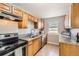 Well-lit kitchen with granite countertops, stainless steel appliances, and wood cabinets at 1248 Moline St, Aurora, CO 80010