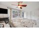 Serene bedroom featuring a ceiling fan, large window, and a door to the outside balcony at 11531 S Deer Creek Rd, Littleton, CO 80127