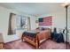 Cozy bedroom with double bed, American flag, and window coverings at 9150 W Bellwood Pl, Littleton, CO 80123