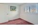 Simple bedroom with carpeted floor, window with blinds, and a door at 9150 W Bellwood Pl, Littleton, CO 80123