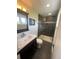 Well-lit bathroom with a modern vanity, a glass-enclosed shower with dark tile at 1158 E Easter Ct, Centennial, CO 80122