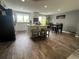Bright kitchen featuring an island with seating, modern appliances, and wood look tile flooring at 1158 E Easter Ct, Centennial, CO 80122