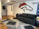 Comfortable living room featuring hardwood floors and a Denver Broncos wall decal at 1158 E Easter Ct, Centennial, CO 80122