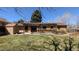 Brick home featuring pergola covered patio, grassy yard and storage shed in the fenced backyard at 3960 Cody St, Wheat Ridge, CO 80033