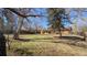 Large backyard with mature trees, lush grass, and a cozy pergola covered patio, perfect for outdoor living at 3960 Cody St, Wheat Ridge, CO 80033