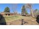 Large backyard with mature trees, green grass, and a pergola covered patio, and privacy fence at 3960 Cody St, Wheat Ridge, CO 80033