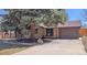 Single-Gathering house featuring a brick exterior, attached garage, and a mature tree in the front yard at 3960 Cody St, Wheat Ridge, CO 80033