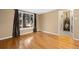 Hardwood floors shine in this living room with a large picture window and dark curtains at 3960 Cody St, Wheat Ridge, CO 80033
