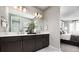 Elegant bathroom featuring a double vanity, modern lighting, and a view into the bedroom at 9192 Telluride Ct, Commerce City, CO 80022