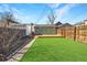 A spacious backyard with a deck, artificial grass, a wooden fence, and a small shed at 3726 N High St, Denver, CO 80205