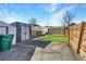 A backyard featuring an artificial lawn, storage shed, gravel area, and wooden fence at 3726 N High St, Denver, CO 80205