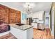 Modern kitchen with stainless steel appliances, granite countertops, and a stylish brick accent wall; perfect for cooking and entertaining at 3726 N High St, Denver, CO 80205