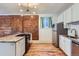 Modern kitchen with stainless steel appliances, granite countertops, and a stylish brick accent wall; perfect for cooking and entertaining at 3726 N High St, Denver, CO 80205