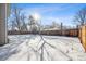 Snowy backyard with wooden fence and tree at 6663 Zinnia St, Arvada, CO 80004