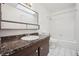 Bathroom with tub, sink, and dark vanity at 6663 Zinnia St, Arvada, CO 80004