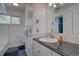 Bright bathroom featuring a tile shower/tub, white vanity with granite countertop, and black slate floors at 7761 S Wellington St, Centennial, CO 80122