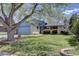 Charming, well-kept home featuring a spacious front yard with lush green grass and mature trees at 7761 S Wellington St, Centennial, CO 80122