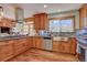 Gourmet kitchen with stainless appliances, granite counters, custom cabinets, and hardwood flooring at 7761 S Wellington St, Centennial, CO 80122