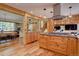 Charming kitchen boasts wood cabinetry, stainless appliances, an island gas cooktop, and eat-in dining area at 7761 S Wellington St, Centennial, CO 80122