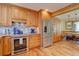 Kitchen features stainless steel appliances, wood cabinets, granite countertops, and eat-in dining area at 7761 S Wellington St, Centennial, CO 80122