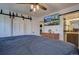 Spacious main bedroom featuring sliding barn doors and a flat screen television at 7761 S Wellington St, Centennial, CO 80122