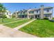 Row of townhomes with manicured lawns and sidewalks on a sunny day at 1622 S Idalia Cir # E, Aurora, CO 80017
