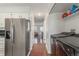 Hallway showcasing hardwood floors, kitchen with stainless steel fridge, and laundry area with modern machines at 1622 S Idalia Cir # E, Aurora, CO 80017