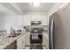 Well-lit kitchen featuring white cabinets, stainless steel appliances, and granite countertops at 1622 S Idalia Cir # E, Aurora, CO 80017