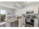 Bright kitchen with white cabinets, granite countertops, stainless steel appliances, and access to outdoor area at 1622 S Idalia Cir # E, Aurora, CO 80017