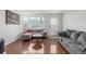 Inviting living room featuring hardwood floors, a gray sectional, and natural light from a large window at 1622 S Idalia Cir # E, Aurora, CO 80017