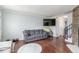 Cozy living room with hardwood floors, a gray sofa, and a modern TV mounted on the wall at 1622 S Idalia Cir # E, Aurora, CO 80017