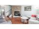 Spacious living room with stone fireplace, hardwood floors, comfortable seating, and stairway access at 1622 S Idalia Cir # E, Aurora, CO 80017